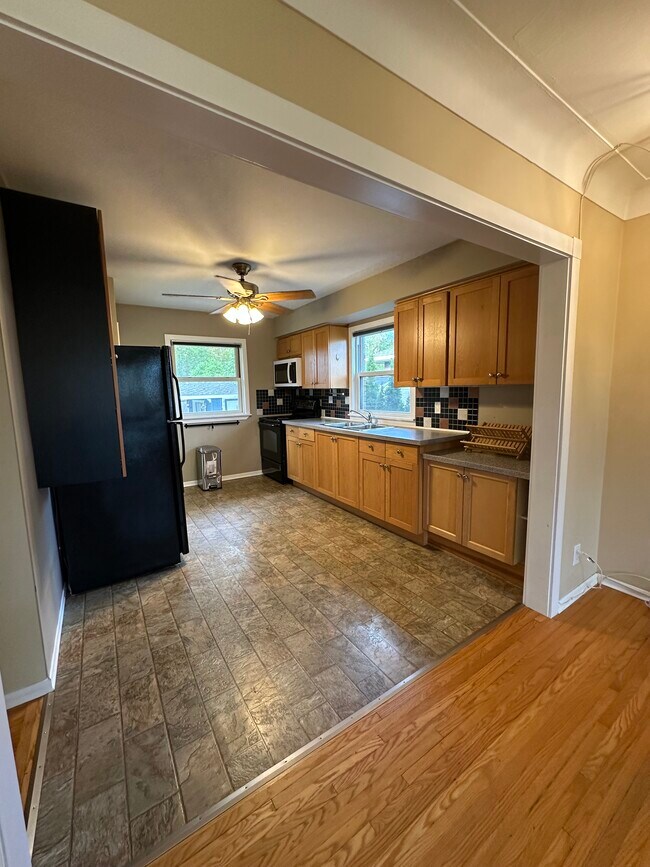 Open, sunlit kitchen with two windows. - 183 Grove Park Dr