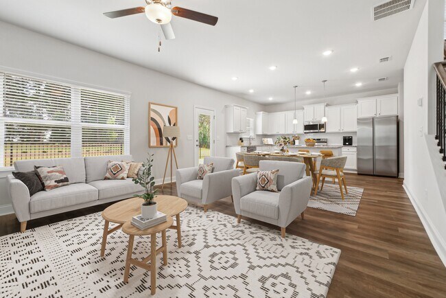 Una sala de estar refinada que ofrece una vista elegante de la sala de estar y el comedor de la casa. - Alma Farms