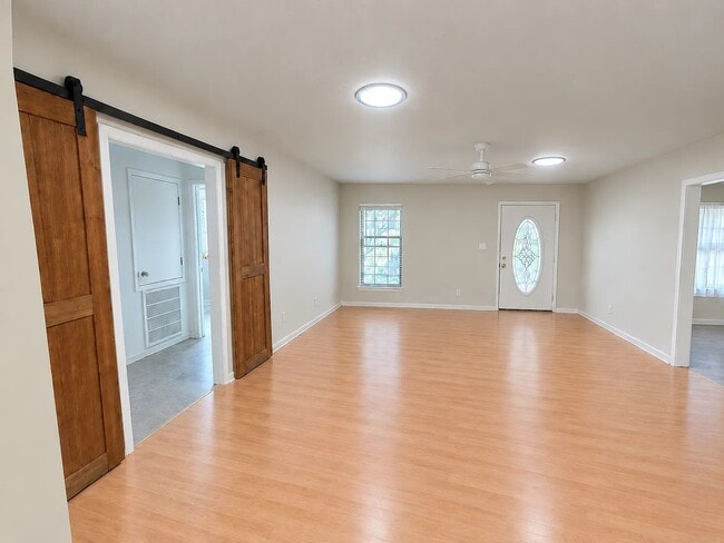 Large living room separates bedrooms, with the primary bedroom and bathroom on one side, and sliding