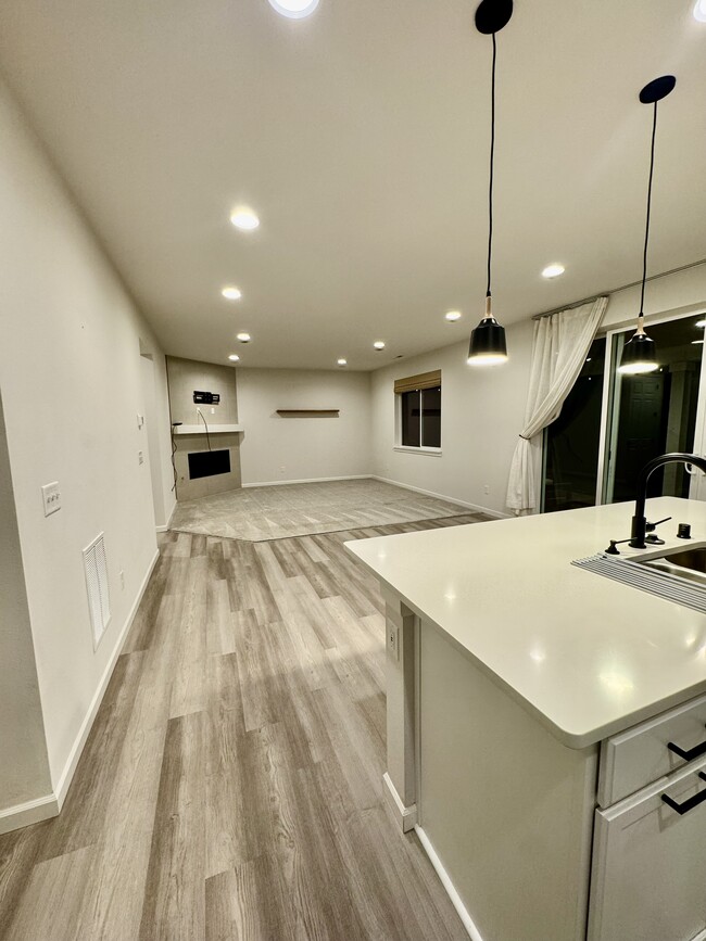 Living room and kitchen, with dual siding doors to back patio - 6750 Skipper Ln SE