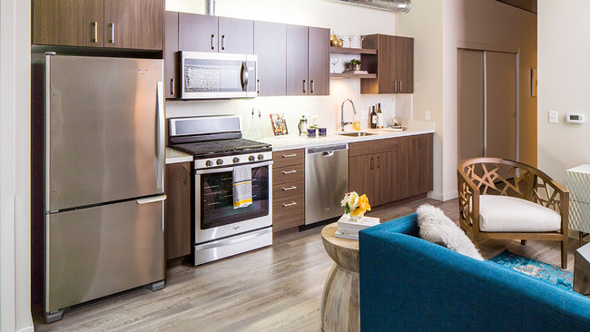 Modern kitchens outfitted with stainless steel appliances, and quartz countertops with tile backsplashes - Modera Pearl Apartments