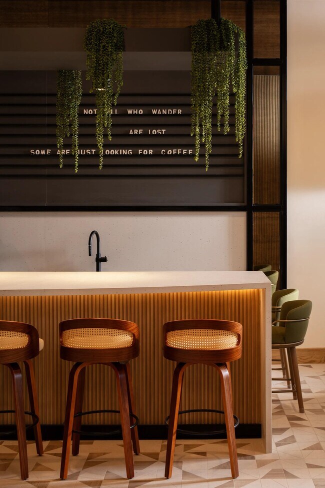 A resident coffee bar with warm wood detailing and ambient lighting—your go-to spot before heading out along Rio Salado. - Modera Rio Salado