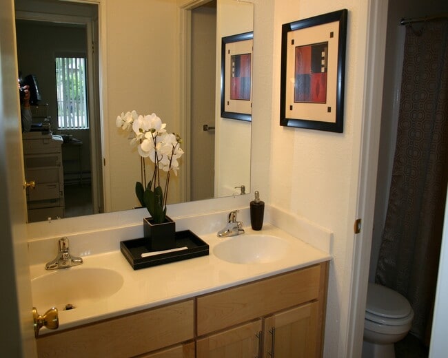 Bathroom with double vanity, oak cabinetry and white countertop