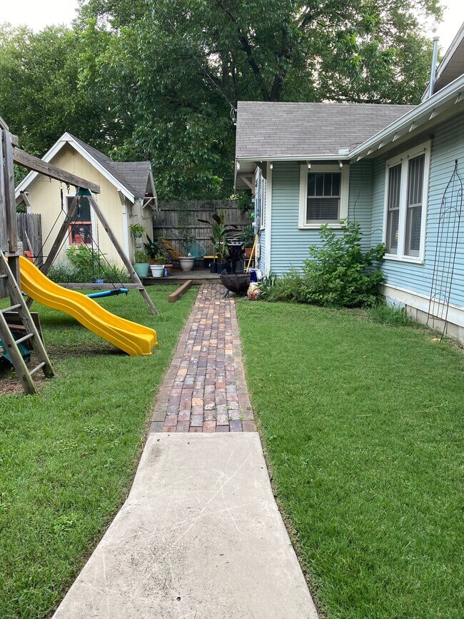 Backyard with storage shed, deck, and swingset. - 1003 Egan St