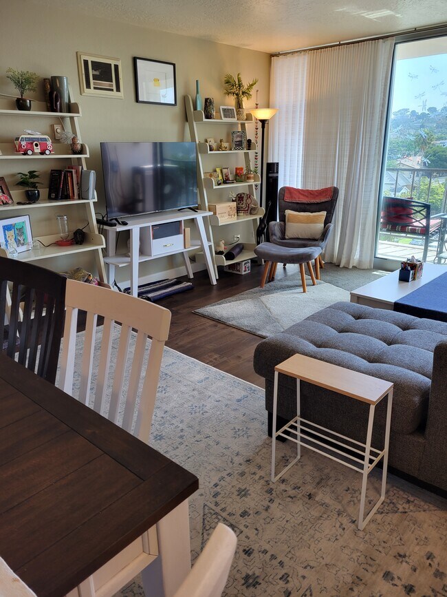 Open plan kitchen, dining, and living room with full-slide floor-to-ceiling doors leading to balcony - 4944 Cass St Condo