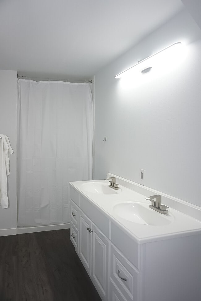 Three bathrooms with showers are shared between five rooms.