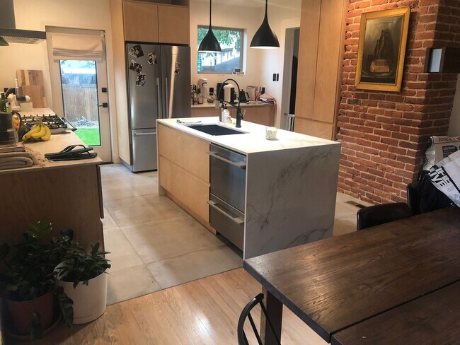 Chef's kitchen with high end appliances, countertop draped kitchen island, and 36 inch range! - 1235 S University Blvd