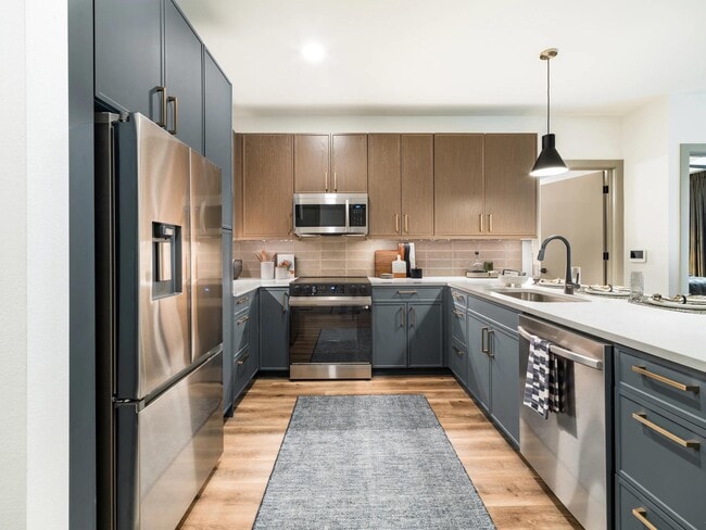 Gourmet kitchens feature quartz countertops, custom cabinetry, stainless steel appliances, and generous storage for a streamlined cooking experience.