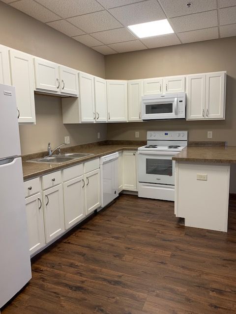 Modern kitchen with elegant white cabinetry, stainless steel appliances, and rich wood flooring, perfect for culinary creativity.