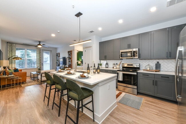 Kitchens are complete with an entertaining island and quartz countertops. - Elevate West Village Apartments