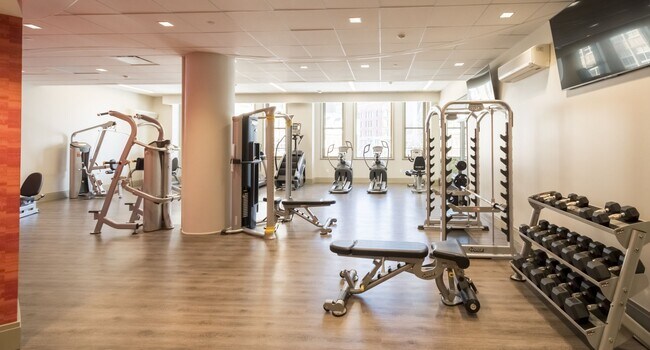 Fitness center featuring cardio equipment, strength-training machines, mirrored walls, and wellness