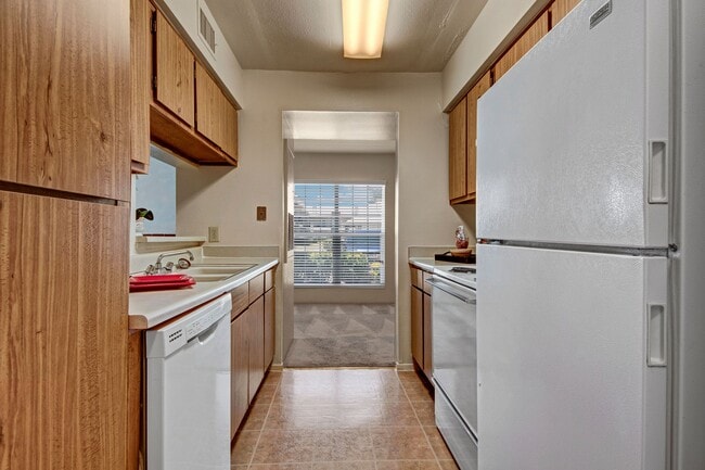 A kitchen with lots of cabinet space and easy access to the dining area - High Plains Apartments