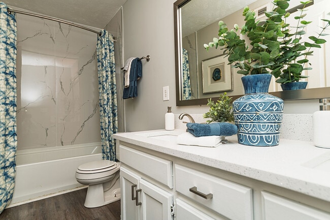 Baño luminoso con encimeras de granito y bañera con protector contra salpicaduras de mármol.