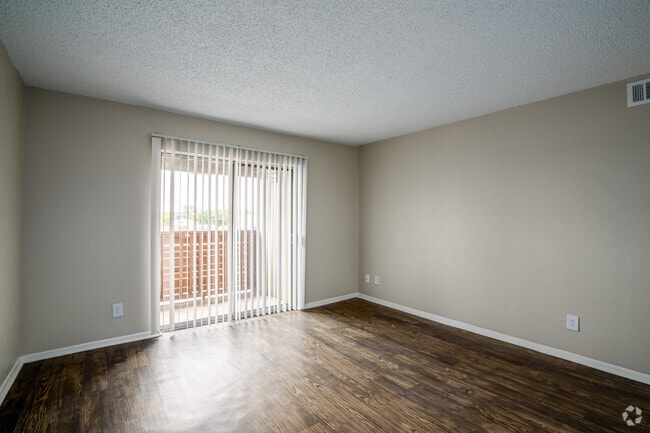 1BR, 1BA - 660SF - Living Room large windows and wood-style flooring in Waco apartments. - Madeira Apartments