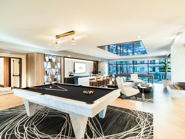 This stylish resident lounge features a striking marble pool table, cozy seating, and fireplace views for a perfect blend of leisure and comfort.