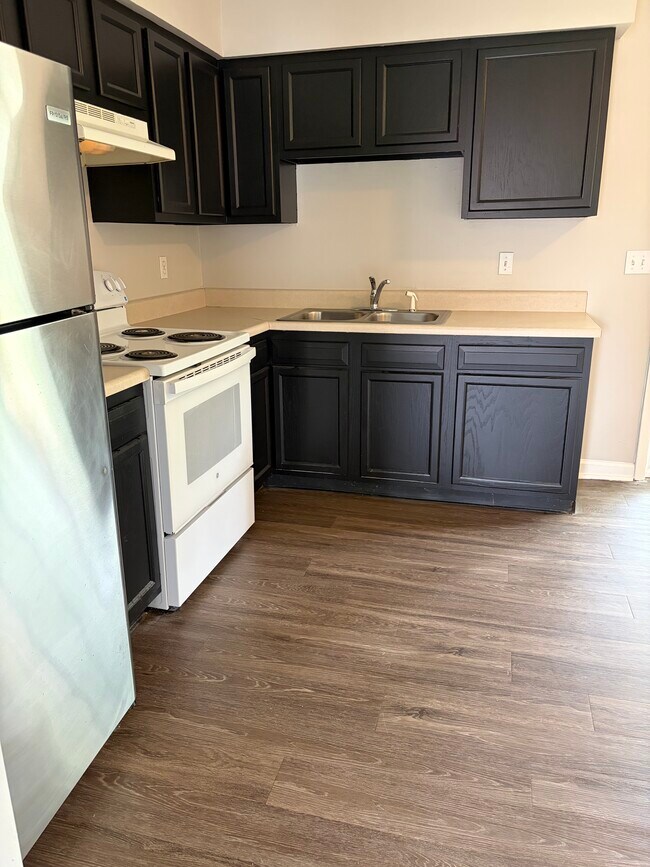 Large kitchen with new fridge and freshly painted cabinets