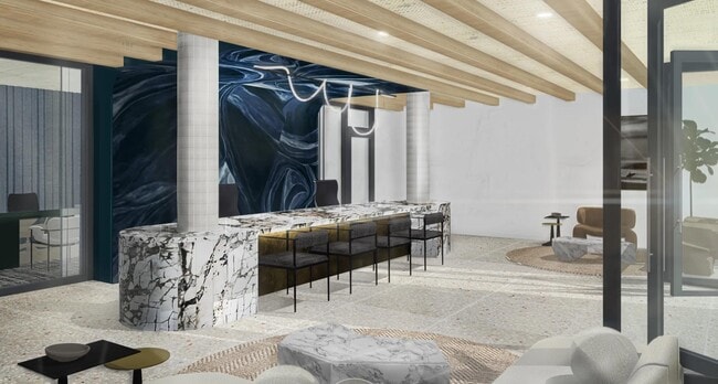 A striking leasing lounge welcomes you home with statement stone, layered seating, and art-driven design. - Modera Melrose