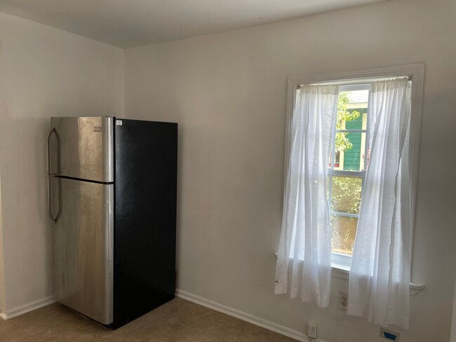Refrigerator and dining area. - 1230 Mandeville St Unit B