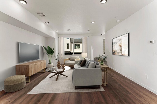 Elegant living room with modern decor, large windows for natural light, cozy seating, and stylish wooden flooring.