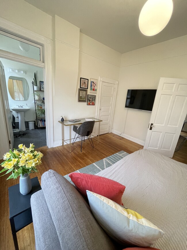 Front Bedroom w/ Bed and view into en suite full bathroom - 215 Walter St NE House