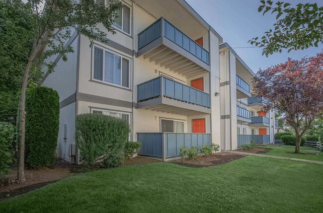 Exterior view of Foster Creek Apartments in Tukwila, with lush landscaping and bright building façade.