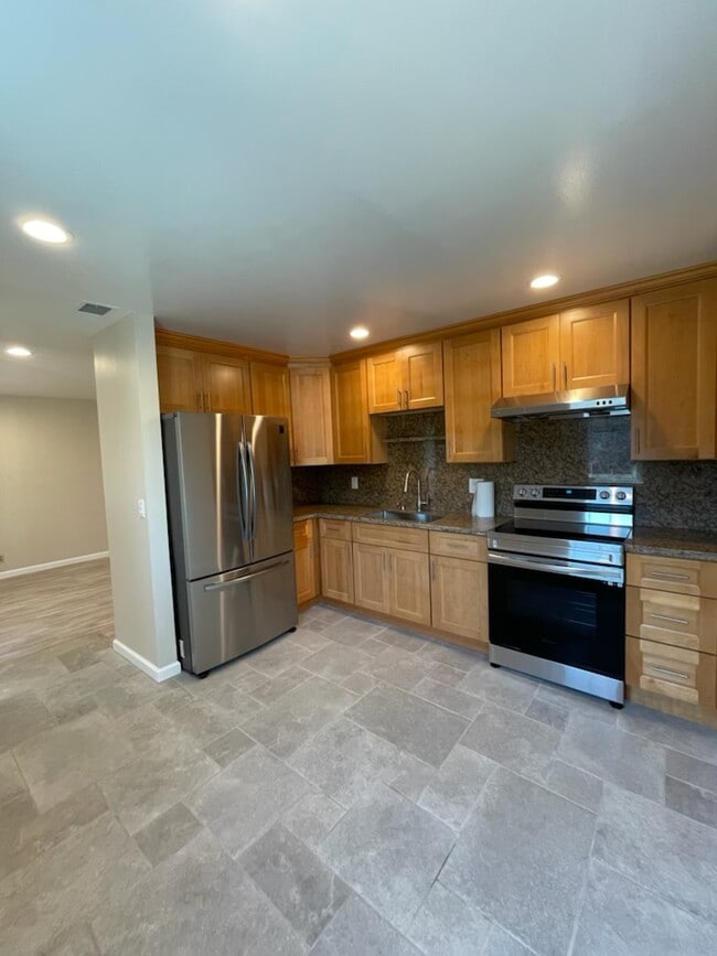Kitchen with large refrigerator and stovetop - 526 Doyle Rd Apartments Unit 4