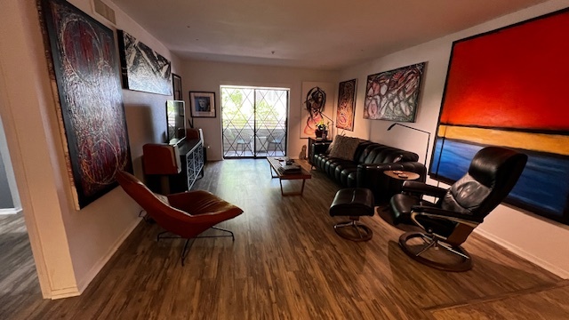 Living room with new vinyl plank flooring, motorized power shade, (no blinds) Very contemporary. - 7777 E Main St Condo Unit ScottsdaleSprings