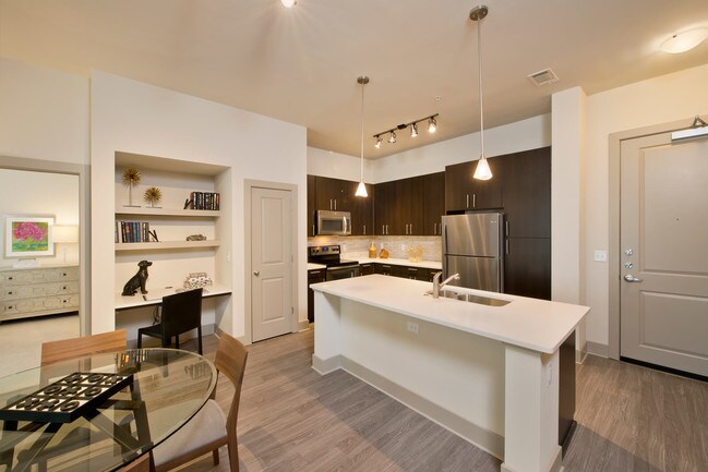 Open-concept gourmet kitchens with stainless steel appliances, granite slab countertops, custom cabinentry, and natural stone backsplash