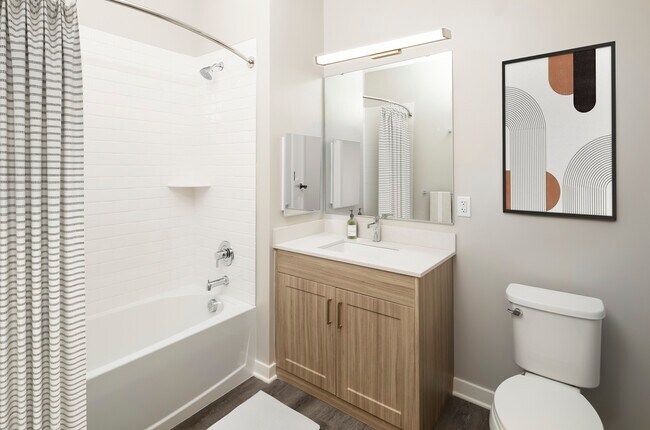 Signature Collection bath with quartz countertop, oak cabinetry, and hard-surface flooring