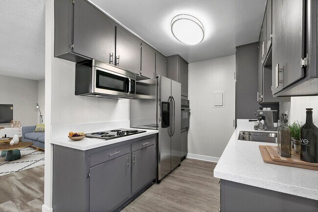 Spacious kitchen with stainless steel fridge, oven, and microwave.