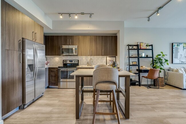 Open Kitchen with Island Seating and View into Living Room - South of Atlantic Luxury Apartments