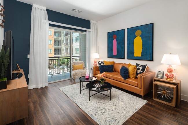 Sala de estar de un apartamento con muebles contemporáneos y una gran puerta de patio. - 675 N. Highland