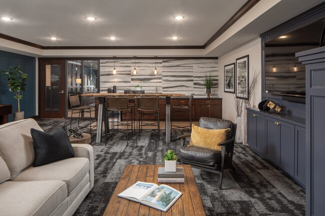 Lounge area with couch, tables, and chairs, with breakfast bar at The Whitley.