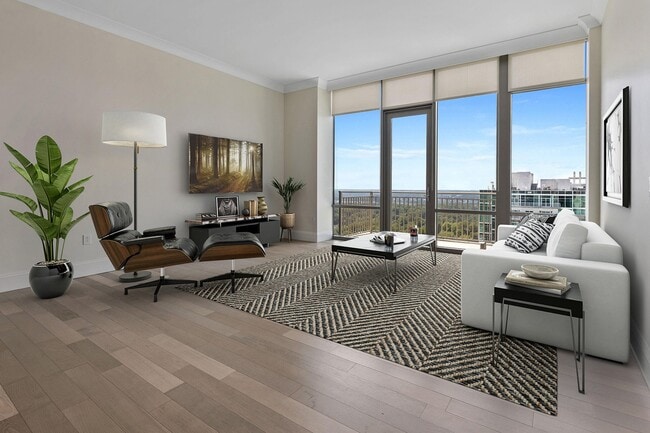Penthouse living elevated—an expansive living space framed by floor-to-ceiling windows, refined finishes, and sweeping views that bring light, comfort, and quiet sophistication home