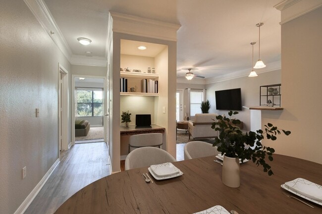 Sala de estar de planta abierta con escritorio incorporado - Carrington at Champion Forest Apartments