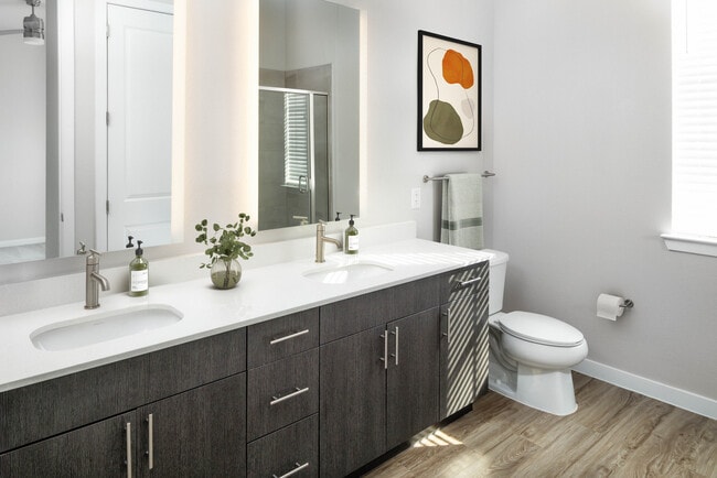 Bath with quartz countertop, tile backsplash, and hard surface flooring
