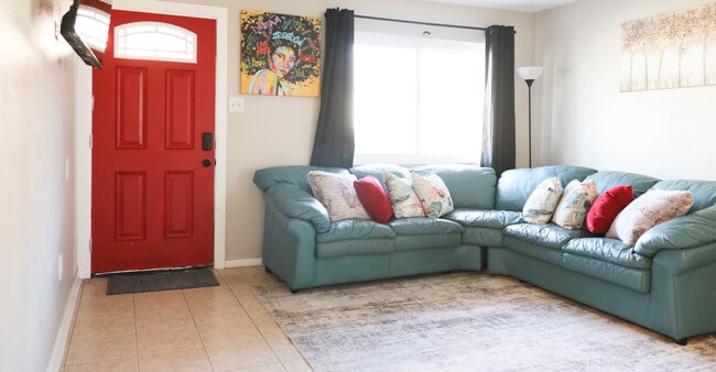 Welcoming living room. Real leather corner sofa, red pops, comfort all around. - 8612 Echo St