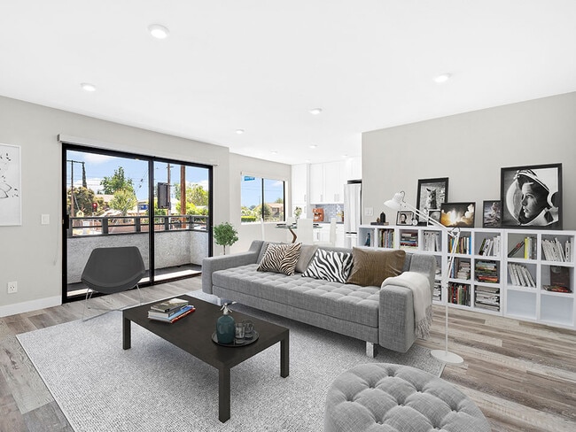 Large hardwood floored living rooms with can lights and view of balcony.