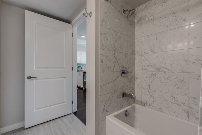 Our bathrooms include floor to ceiling, surround tiling in the bathtub and shower, and light-grey wood-style vinyl flooring for a modern and stylish look.