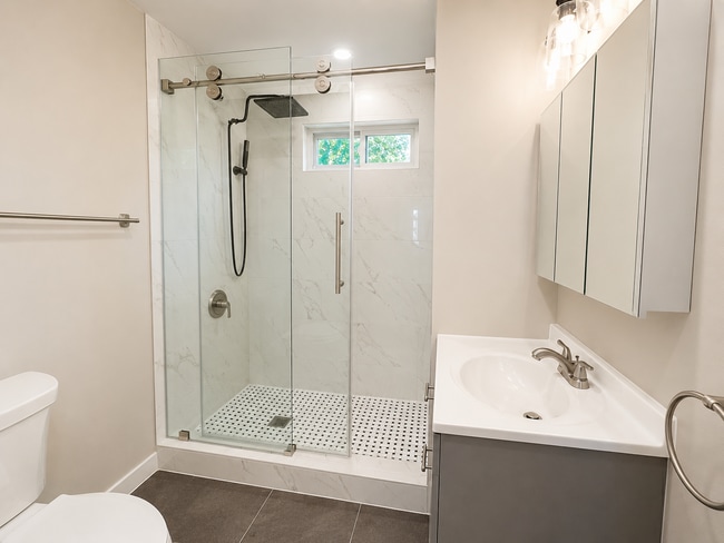 Fully renovated bathroom featuring marble-look shower tile, glass shower door, updated vanity - 78 Orchard St Unit 1