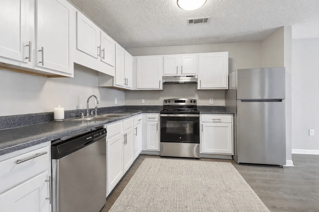 Cook with ease in updated kitchens with crisp white cabinetry and stainless steel appliances, professionally operated by Highlands Vista Group. - Avalon Place