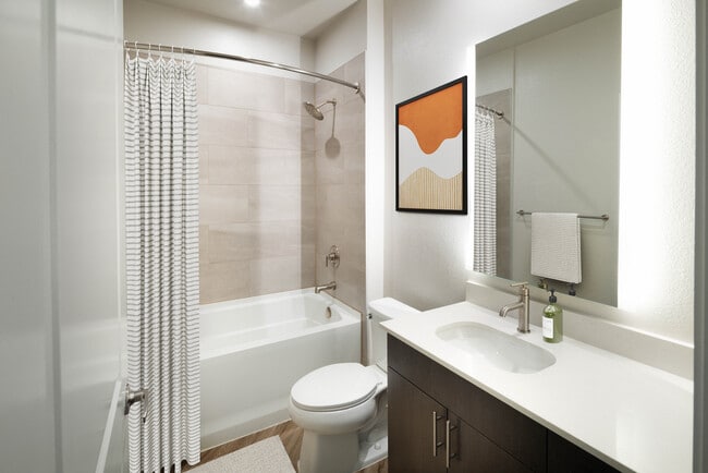 Bath with quartz countertop, tile backsplash, and hard surface flooring