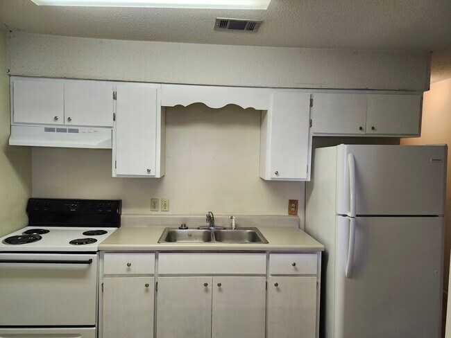 Cocina con gabinetes y encimera recién restaurados. - 44 5th Ave Unidad Shalimar Rentals