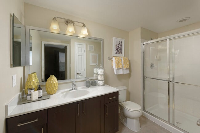 Espresso Package Townhome bathroom with espresso cabinetry, quartz countertop and shower with white tile backsplash