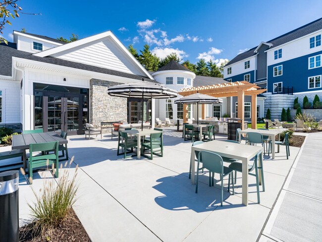 Enjoy the sunshine or dine in the shade—this inviting outdoor space features lounge seating, shaded tables, and a grill-ready pergola setup.