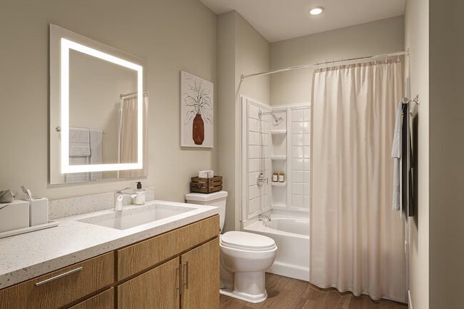 Bright bathroom with a shower-tub combo, vanity storage, and clean finishes.