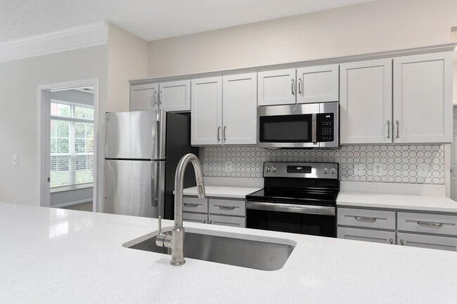 The Charleston Magnolia Premium Renovated Kitchen with Quartz Countertops, Brushed Nickel Fixtures, Gooseneck Kitchen Faucet, Modern Backsplash, Stainless Steel Appliances