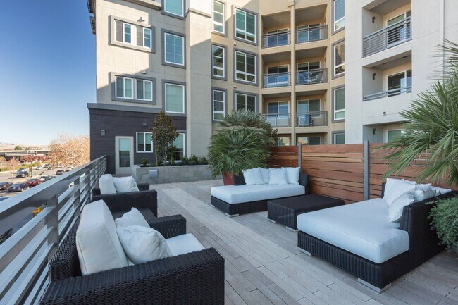 Outdoor sitting area with modern furniture and fire features at Aster Apartments in Dublin, CA. - Aster