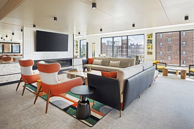 The community lounge includes a kitchen, pool table, smart TV and fireplace.