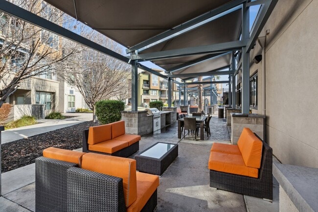 Aspire Apartments Tracy California Luxury Living A patio with black wicker furniture and orange cushions.